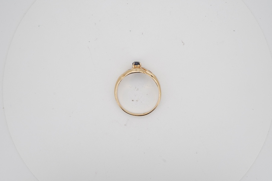 A modern 18k yellow metal and single stone oval cut sapphire set ring, with six stone diamond chip set shoulders, size U/V. gross weight 6 grams.